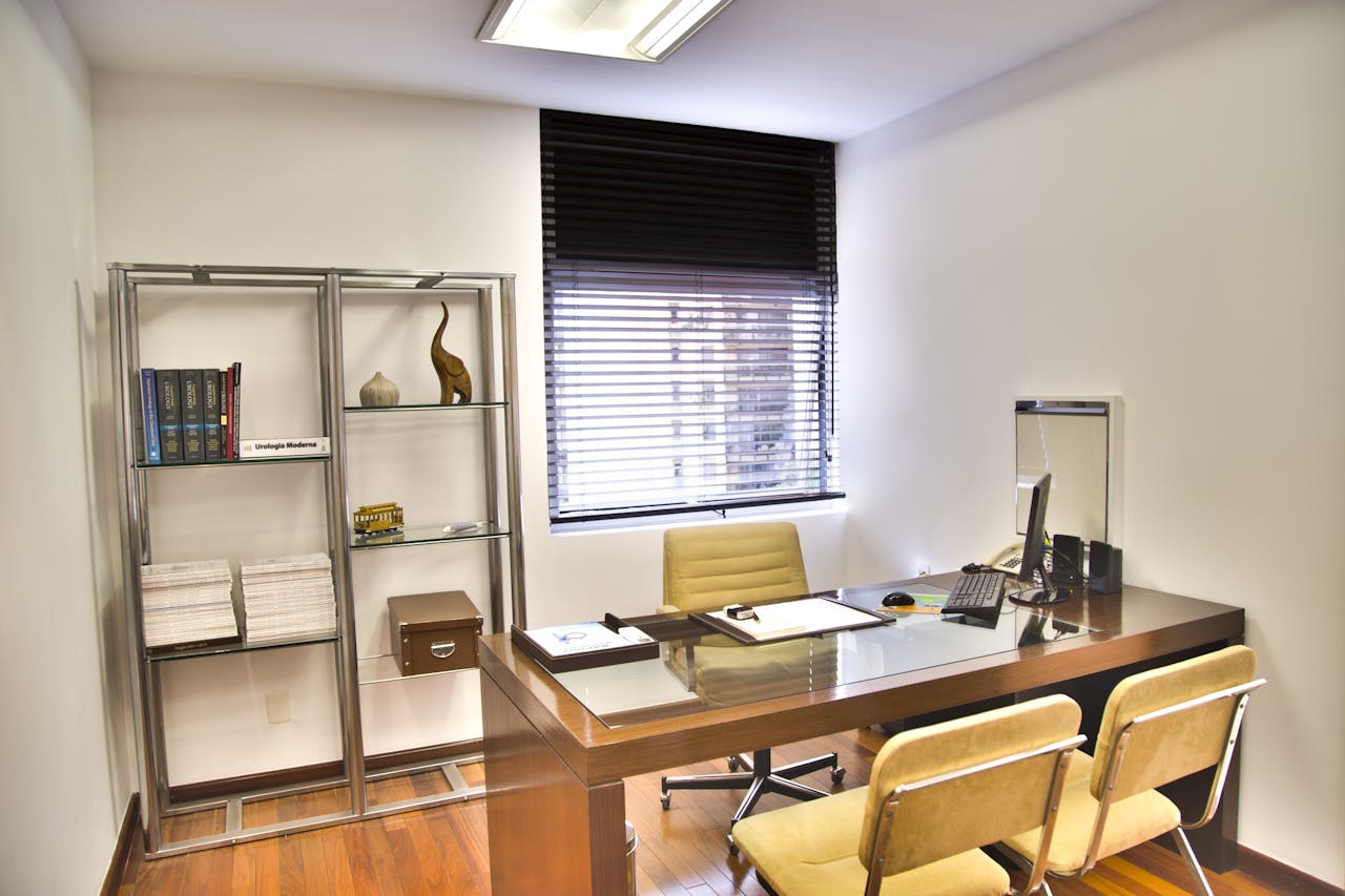 services-04 Sleek and contemporary office space featuring a wooden desk, chairs, and organized shelves.